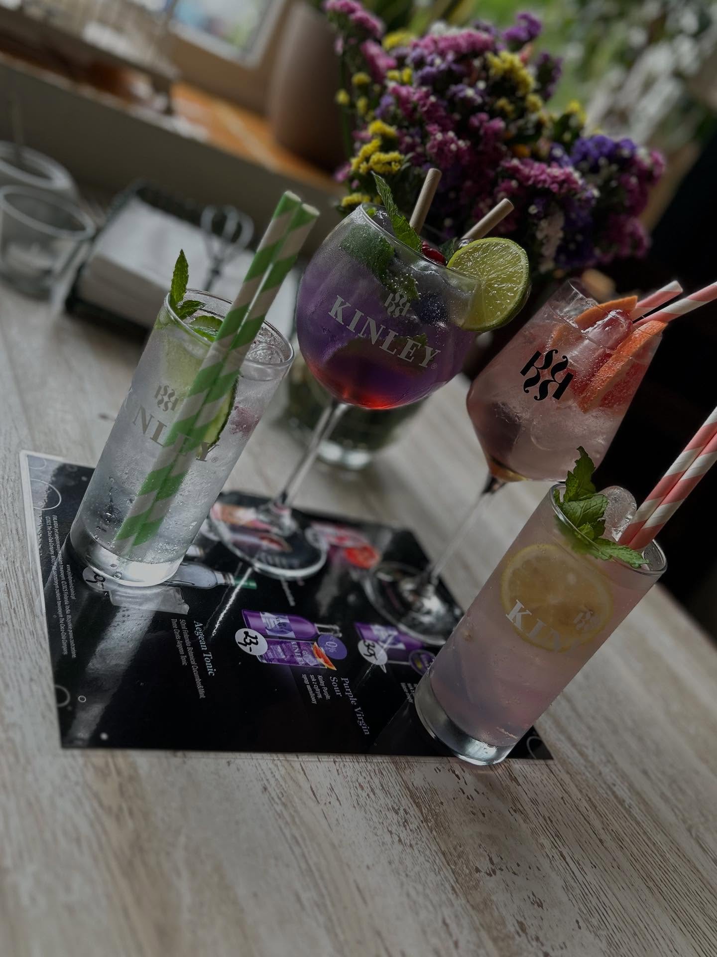 Kolorowe drinki Kinley: mojito, fioletowy drink i różowy grejpfrutowy
